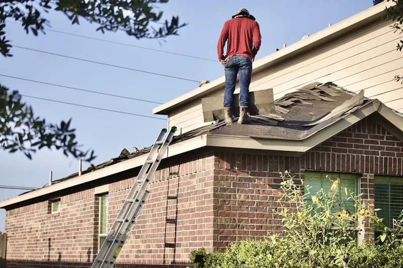 Professional roofer working on a residential roof in Villages of Parker